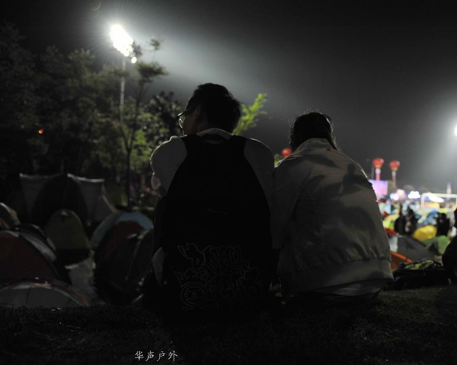 一对情侣依偎着坐在草地上休息。实习生-熊曜霖-摄