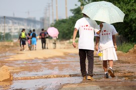 两位毅行者的T恤背面写着“平凡爱心，贵在坚持”的标语，百公里正是需要这份坚持。记者 王立三 摄