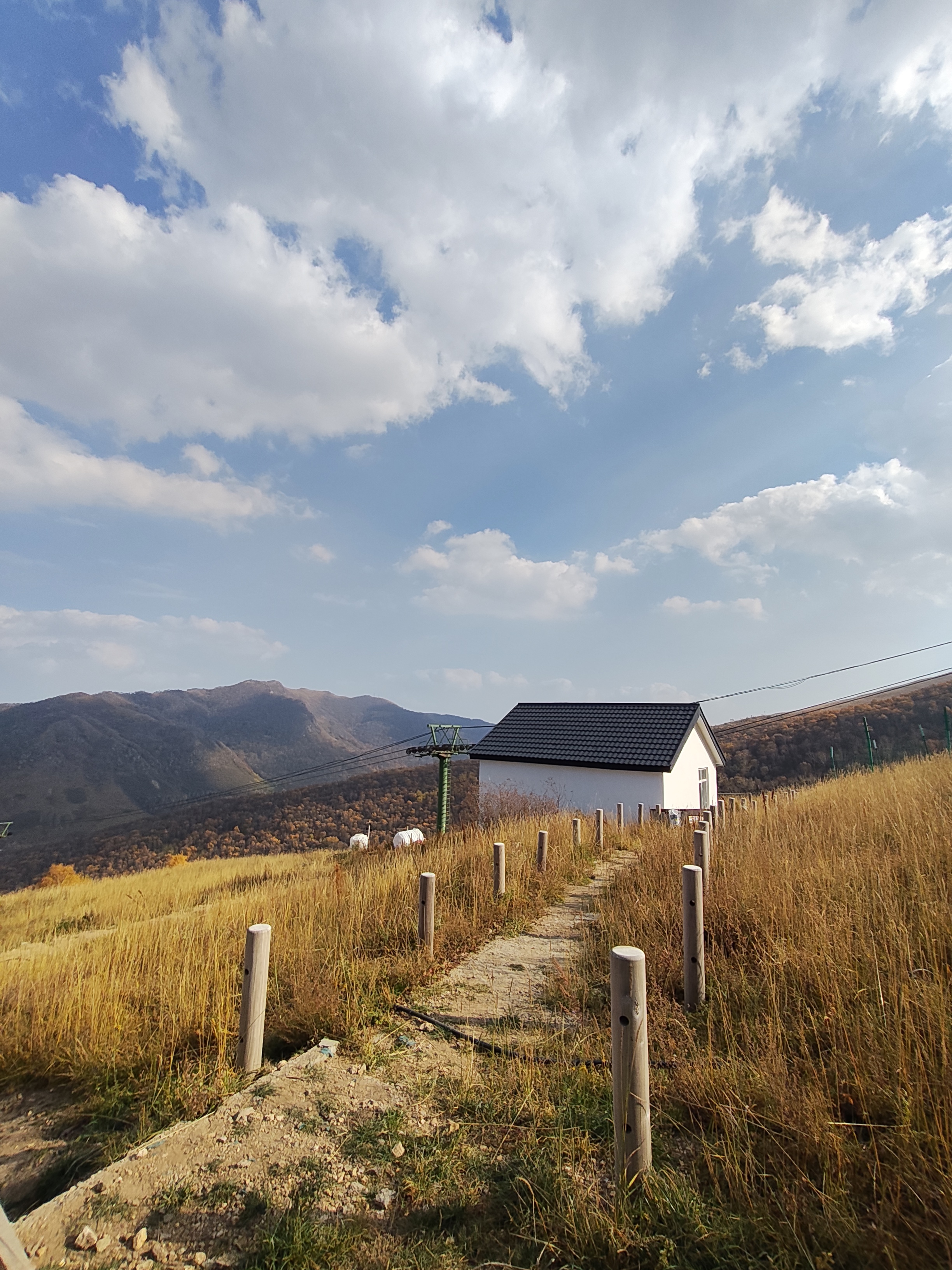 草甸上的围栏、小屋与远山